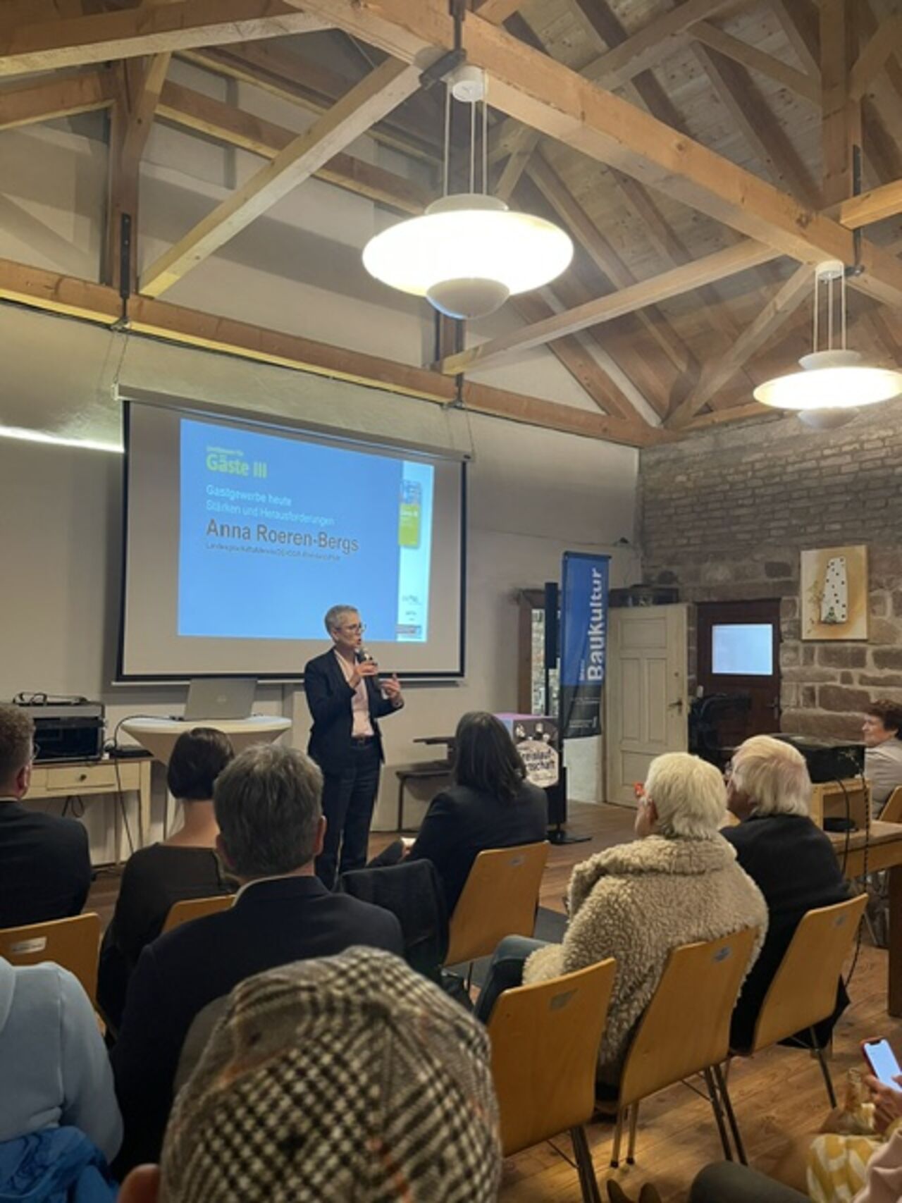 Foto: Dr. Christoph H. Nuehlen Gäste verfolgen den Vortrag von Anna Roeren-Bergs im historischen Saal mit Holzdachkonstruktion des Alten Sägewerks.