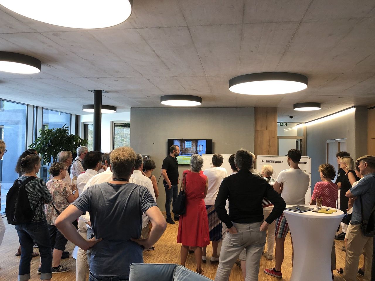 Blick ins Foyer mit Sichtbetondecken und der Besuchergruppe