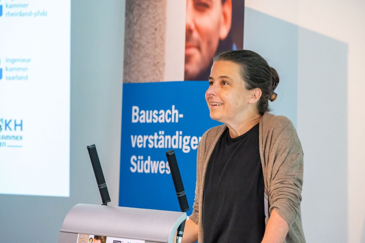 Edda Kurz steht am Rednerpult und begrüßt die Veranstaltung 