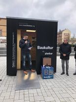 Blick auf die Vorderseite der Box. Herr Arnold steht in der geöffneten Tür.