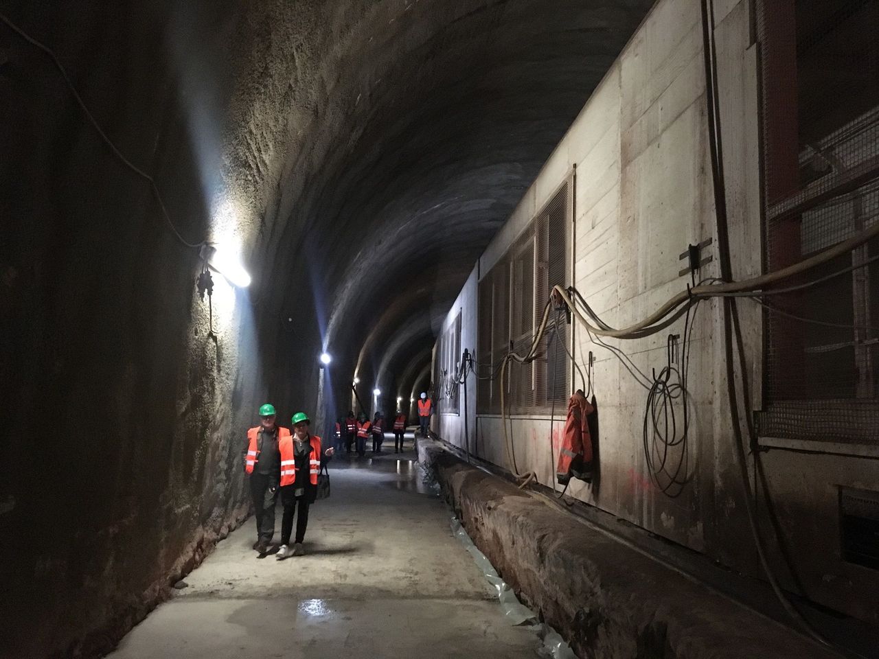 Blick in die Baustelle - beleuchtete Tunnelröhre mit Besuchern.