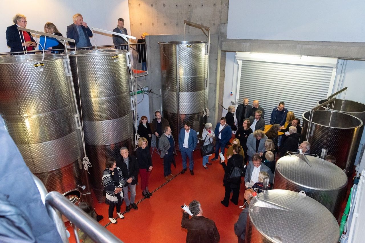 Blick in die Kelterhalle mit Edelstahlsilos und rotem Fußboden