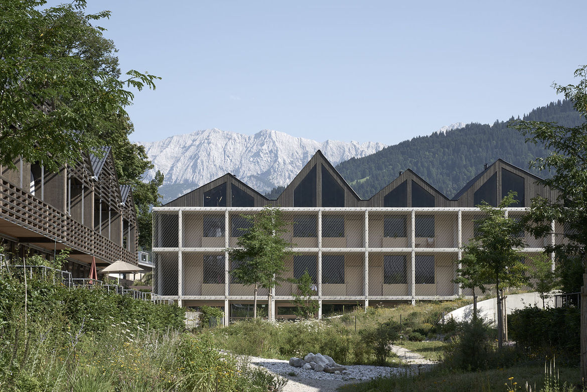 Blick auf das Hotel mit einer Dachlandschaft wie das bergpanorama im Hintergrund.