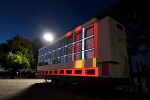 Nachtaufnahme mit Farbprojektionen auf der Fassade des Tiny House