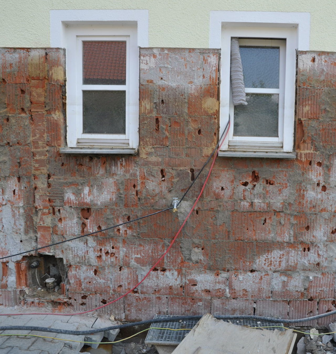 Dunkle Verfärbungen nach Entfernen des Putzes deuten auf eine Heizölbelastung auch im Mauerwerk hin