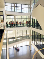 das mehrgeschossige verglaste Foyer mit Treppen und offenen Stegen