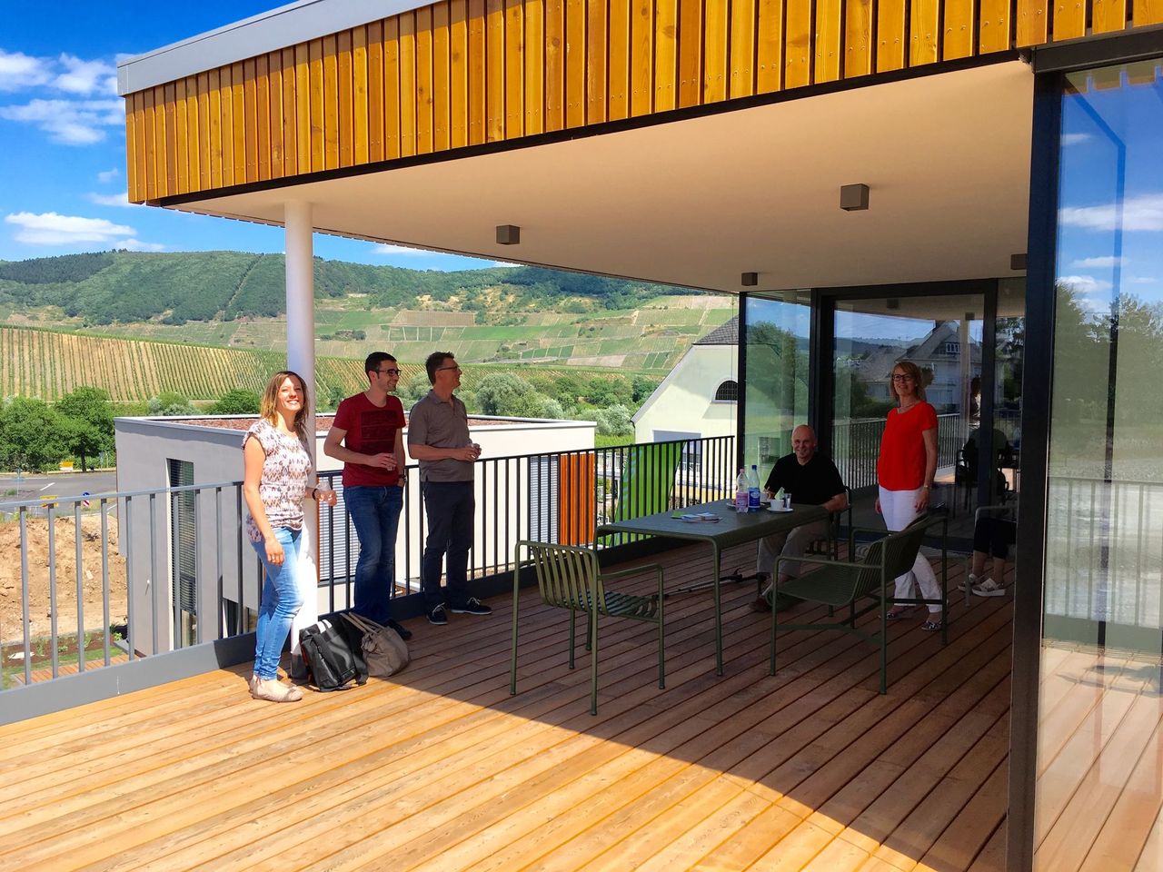 Blick auf die Terrasse mit Holzbohlenbelag eines Wohnhauses mit Besuchern beim "Tag der Architektur".