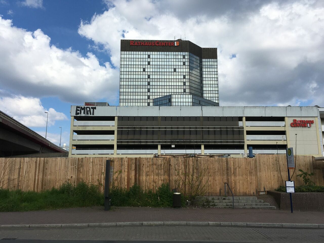 Straßenansicht mit Baustellenzaun und Rathaus