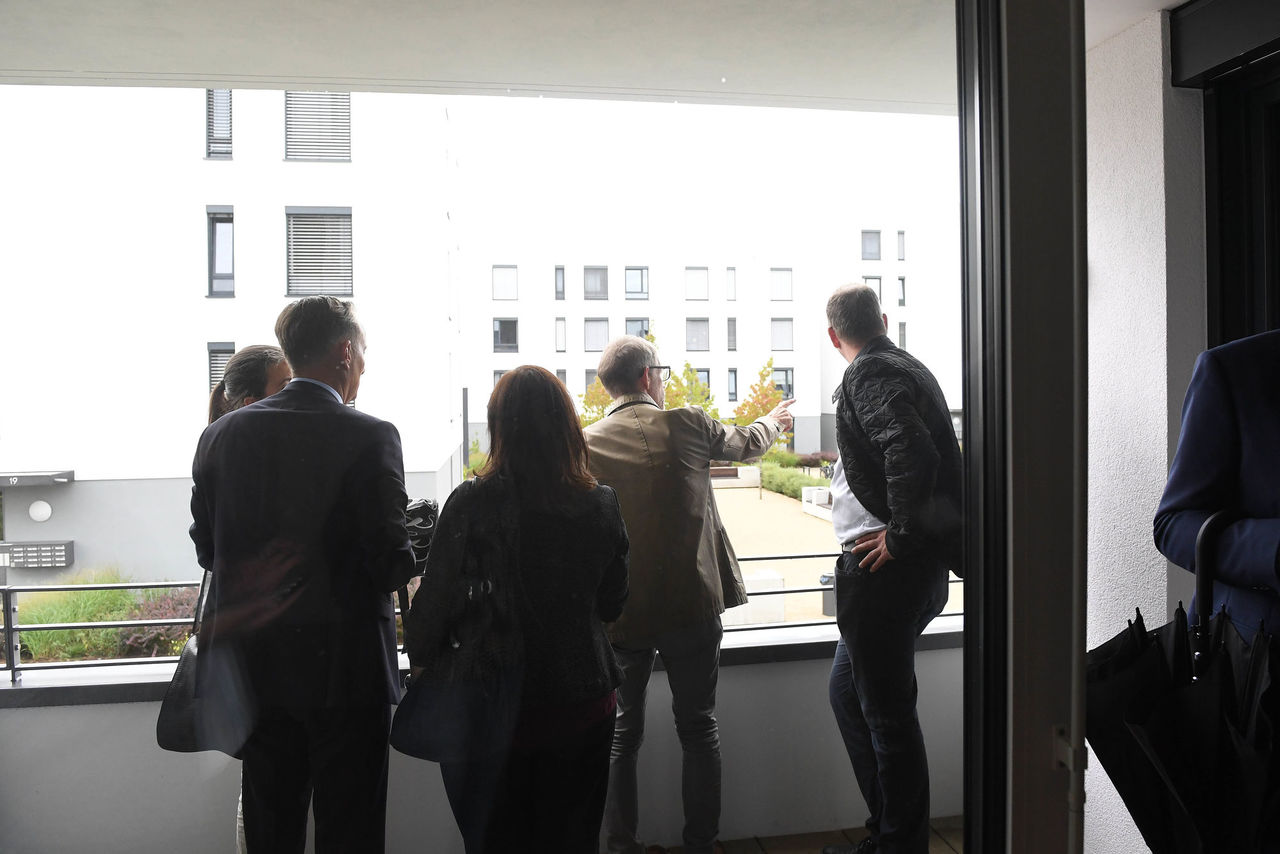 Gruppenmitglieder auf einer Loggia mit Blick auf das Quartier.