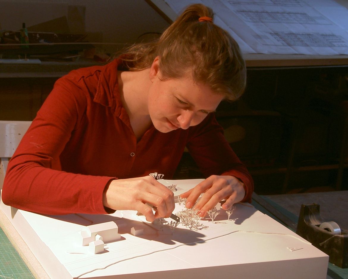 Edda Spangenberg baut konzentriert an einem Architekturmodell.