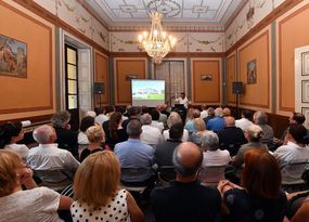 Blick in den historischen Saal mit Kronleuchter, der voll besetzt ist.