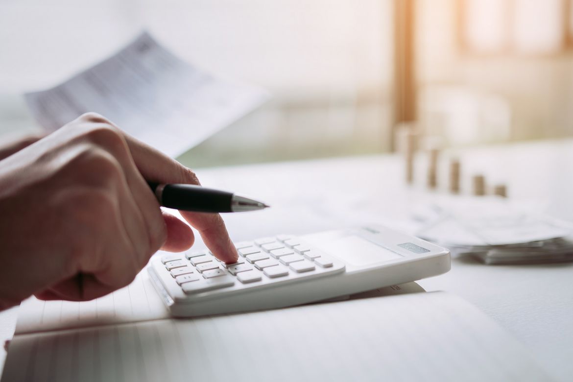 Foto: © wutzkoh - stock.adobe.com Mehr Übersicht: Hand mit Bleistift tippt auf Taschenrechner