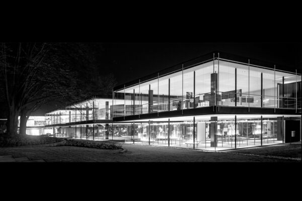 schwarz-weiß Foto eines lichtdurchfluteten Gebäudes bei Nacht