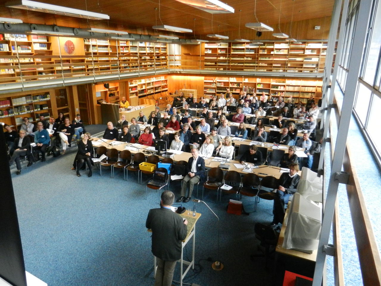 Ein Foto von der Veranstaltung Tatort Altbau, man sieht die Zuhörer in einem großen Saal, wie sie gespannt auf den Redner schauen.