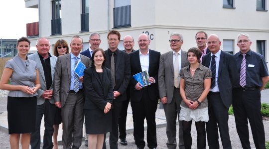 Gruppenfoto mit Minister Dr. Kühl in der Mitte nach dem Besuch eines Generationen übergreifenden Wohnprojektes in Maikammer.
