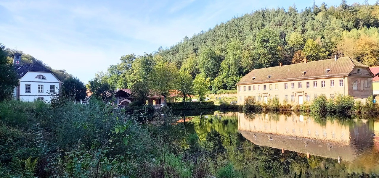 Blick von Süd-Osten über den Teich, Mitte offene Halle, rechts Herrenhaus, links Café